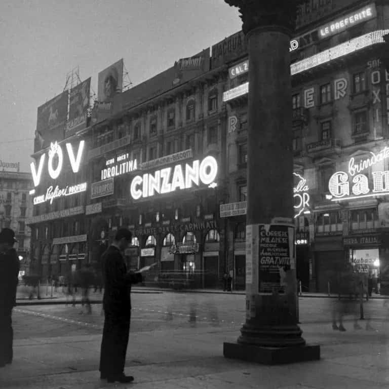 Un uomo legge il giornale sotto le luci al neon di Palazzo Carminati. Fonte: Urban File